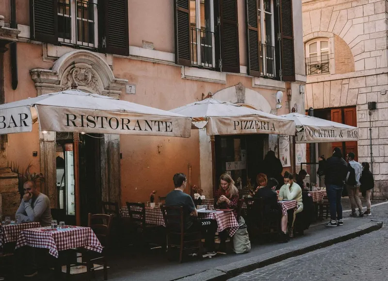 Clienţi st&acirc;nd la masă, la o terasă, la un restaurant din Italia - Foto: Pexels/Gonzalo Mendiola