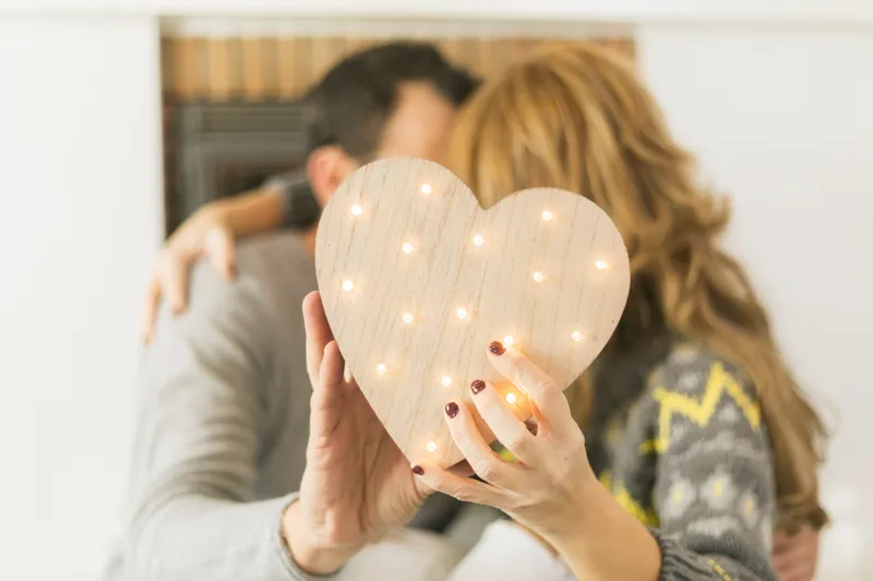 Cuplu adult sărut&acirc;ndu-se și acoperindu-se cu o inimă - Foto: Magnific.com (Imagine cu rol ilustrativ)