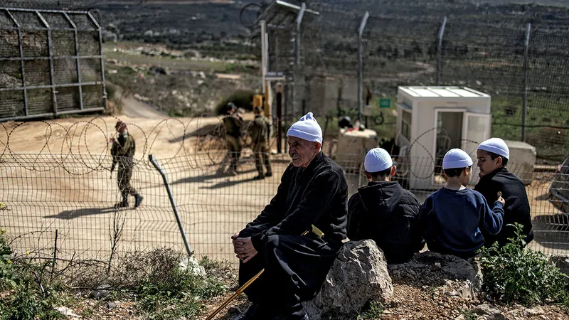ALIANȚĂ POTENȚIALĂ Bărbați druzi lângă o barieră de frontieră în Înălțimile Golan anexate de Israel, pe 14 martie. IDF a încercat să încurajeze contactele cu comunitatea minoritară