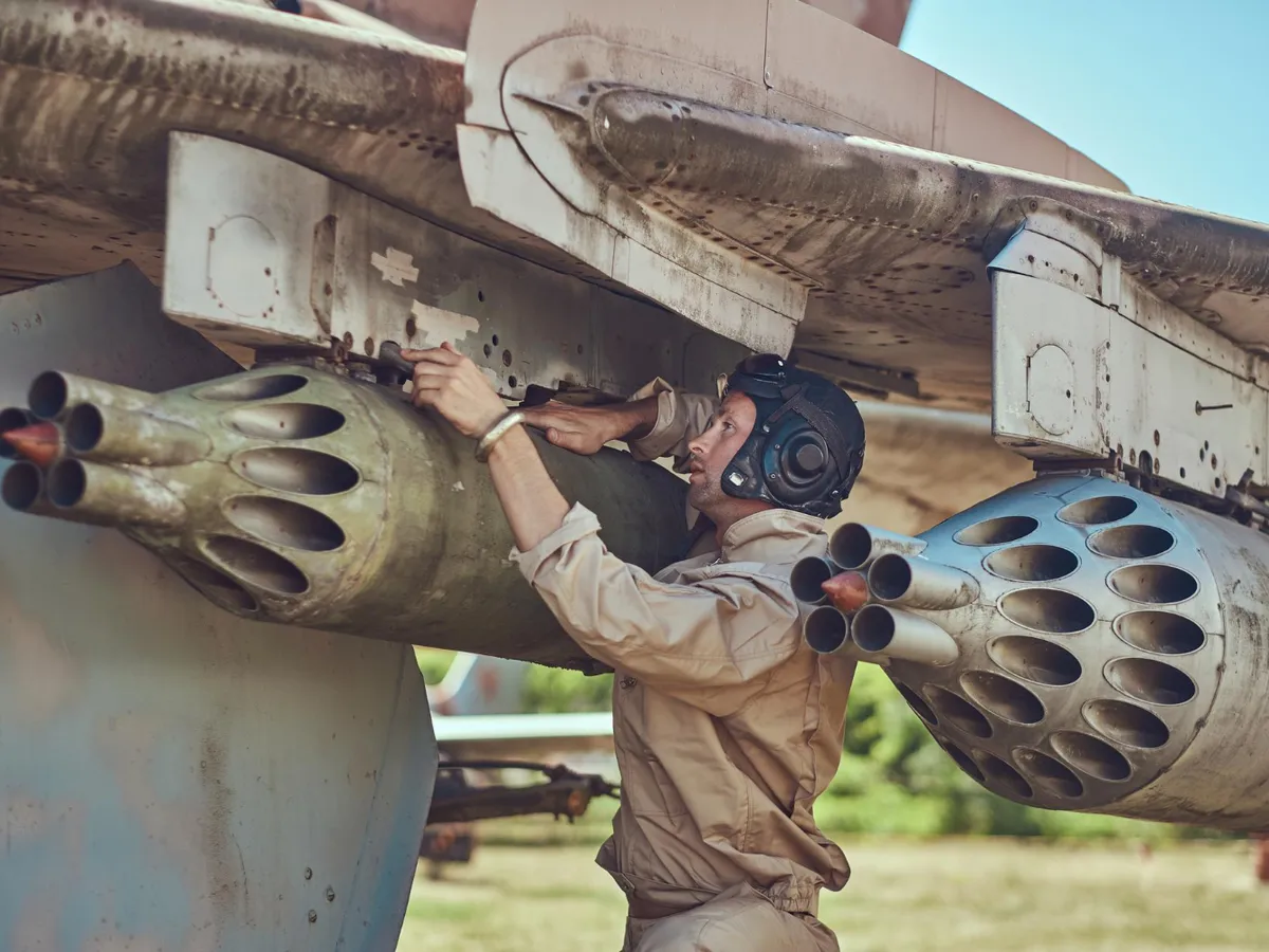 Mecanic în uniformă și cască de zbor repară un vechi avion de război - Foto: Freepik (Imagine cu rol ilustrativ)