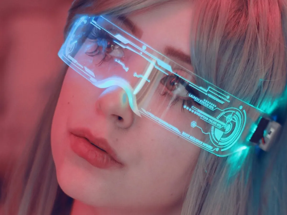 Femeie cu tatuaje uitându-se prin nişte ochelari high-tech - Foto: Pexels/Bianca Salgado