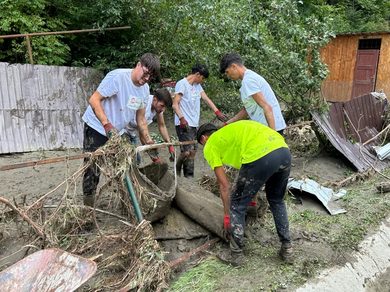Voluntari care ajută la scoaterea bunurilor din locuințele pline de nămol - Foto: Newsweek Romania