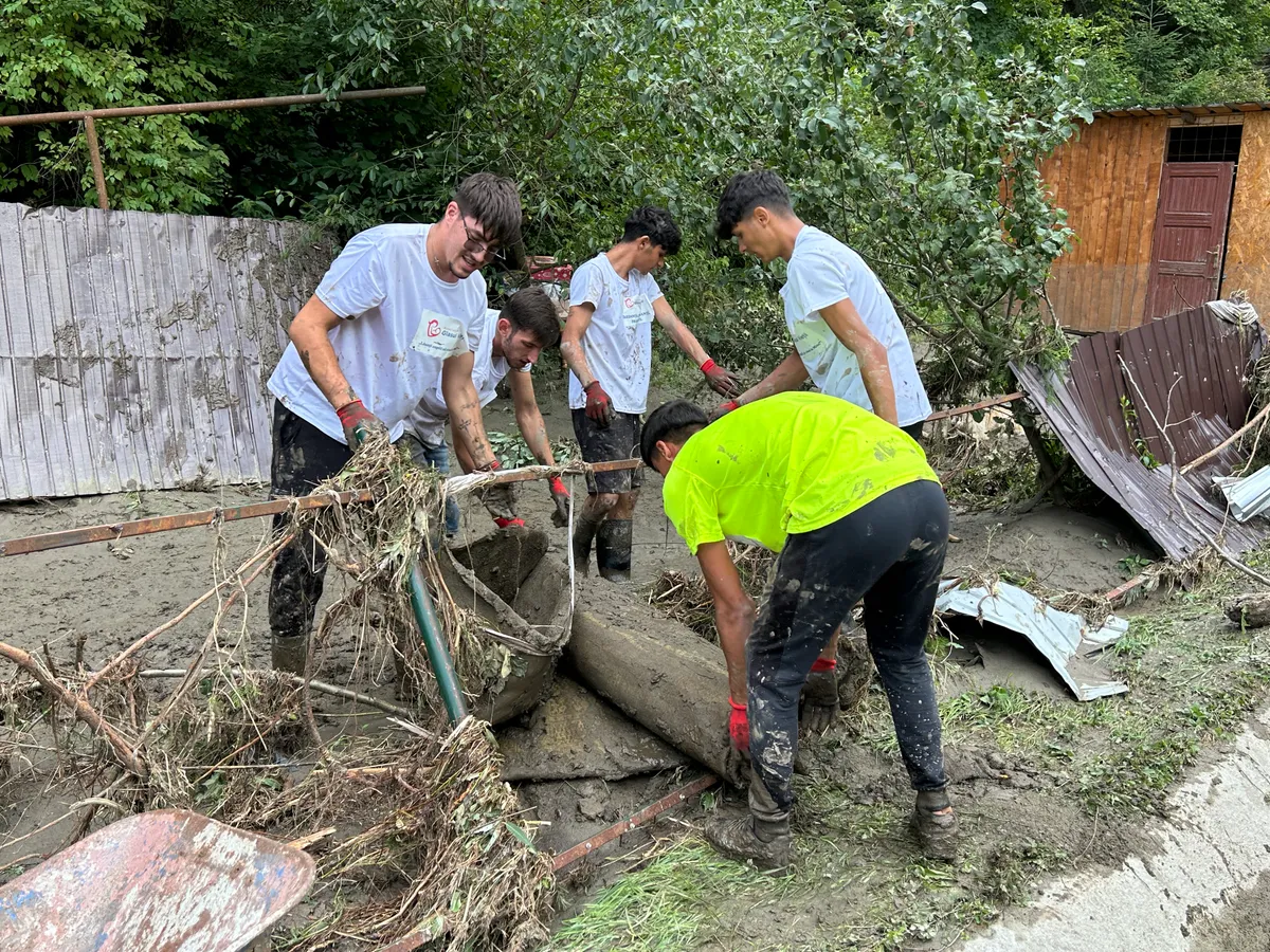 Voluntari care ajută la scoaterea bunurilor din locuințele pline de nămol - Foto: Newsweek Romania