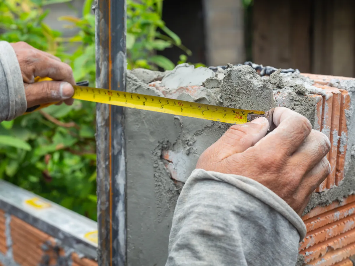 Muncitor în construcții construiește un zid de cărămidă - Foto: Freepik (Imagine cu rol ilustrativ)