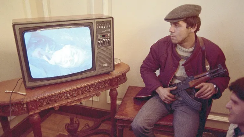 GRANIȚA ISTORIEI  Un tânăr participant la Revoluția din 1989 privește procesul lui Ceaușescu, finalizat cu executarea acestuia. 1989 a fost o nouă graniță pentru cei care au plecat