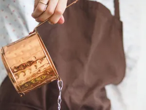 Femeie vărsând apă dintr-un recipient de sticlă - Foto: Pexels/Maria Verkhoturtseva