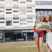 Două tinere în fața unui bloc de apartamente - Foto: Freepik (rol ilustrativ)