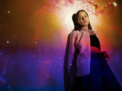 Tânără femeie stând în proiecția texturii universului - Foto: Magnific.com (Imagine cu rol ilustrativ)