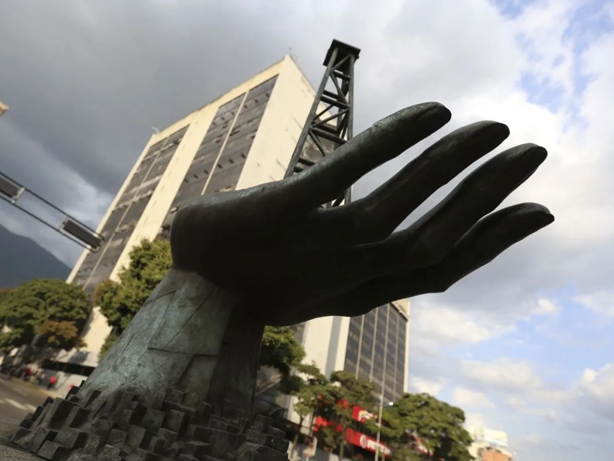 O sculptură a unei mâini care ține o platformă de foraj petrolier, în faţa sediului central al PDVSA, din Caracas - Foto: Profiedia Images