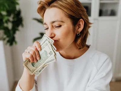 Femeie mirosind bani - Foto: Pexels (cu rol iustrativ)