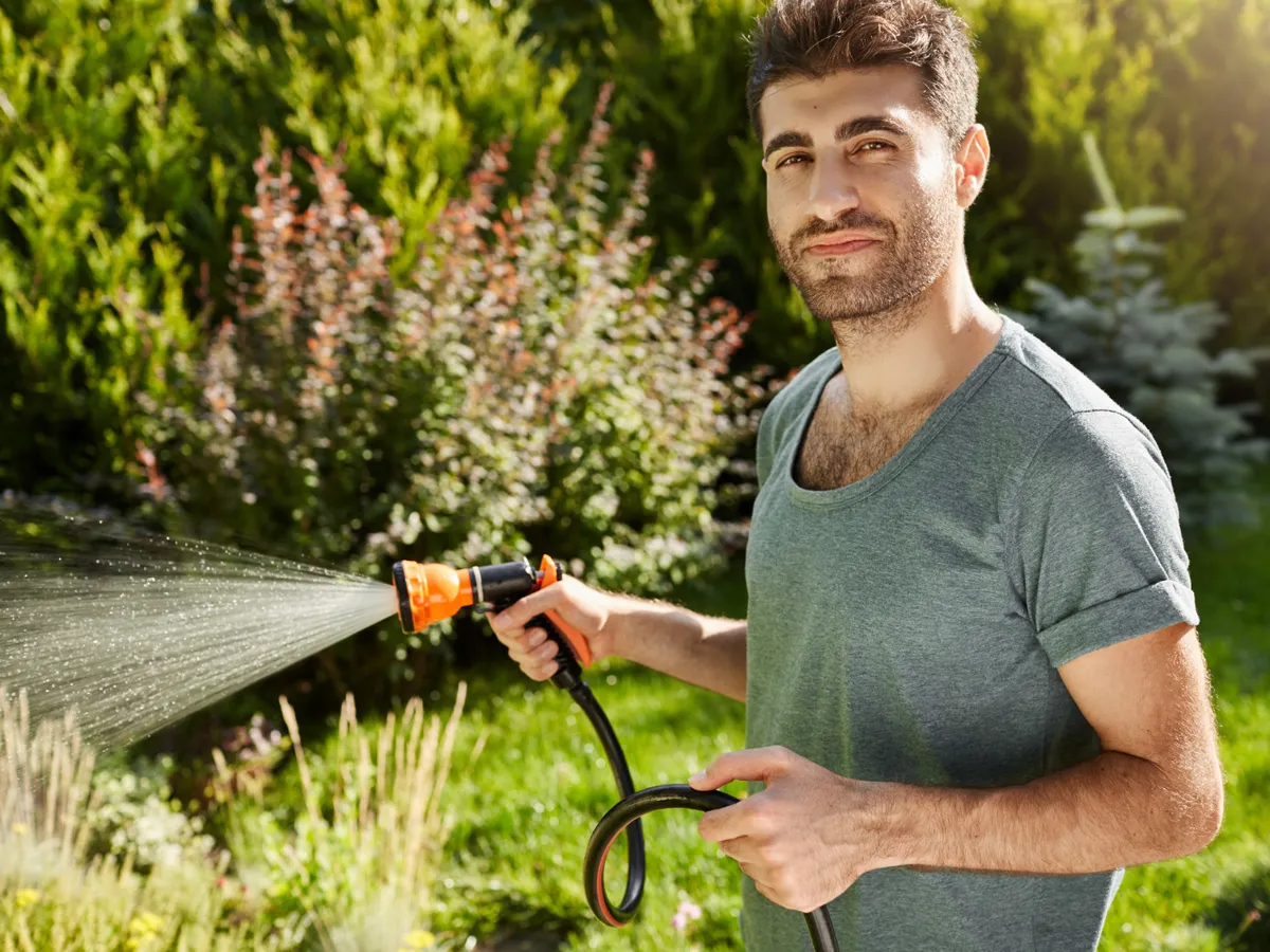 Bărbat care udă gazonul - Foto: Freepik (Imagine cu rol ilustrativ)