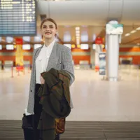 Femeie de afaceri elegant îmbrăcată la un terminal modern de aeroport - Foto: Pexels (Imagine cu rol ilustrativ)