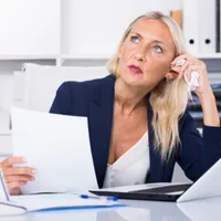 O femeie ține în mână un document - Foto: Magnific (rol ilustrativ)
