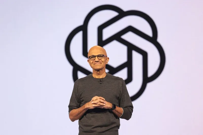 Președintele și directorul executiv al Microsoft, Satya Nadella, vorbește în fața logo-ului OpenAI - Foto: Profimedia Images