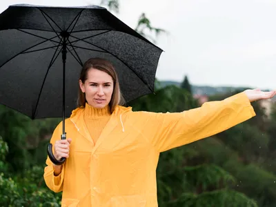 Femeie care ține o umbrelă neagră - Foto: Magnific.com (Imagine cu rol ilustrativ)