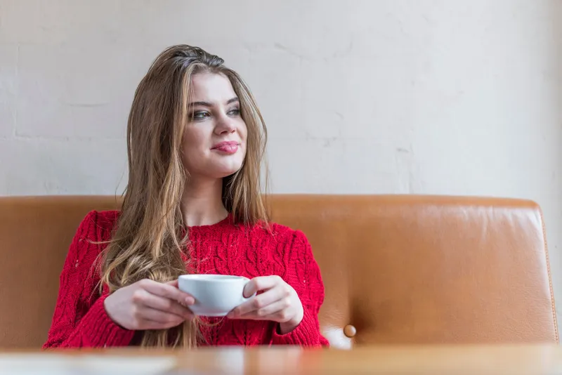 Femeie frumoasă care bea o ceașcă de cafea - Foto: Freepik