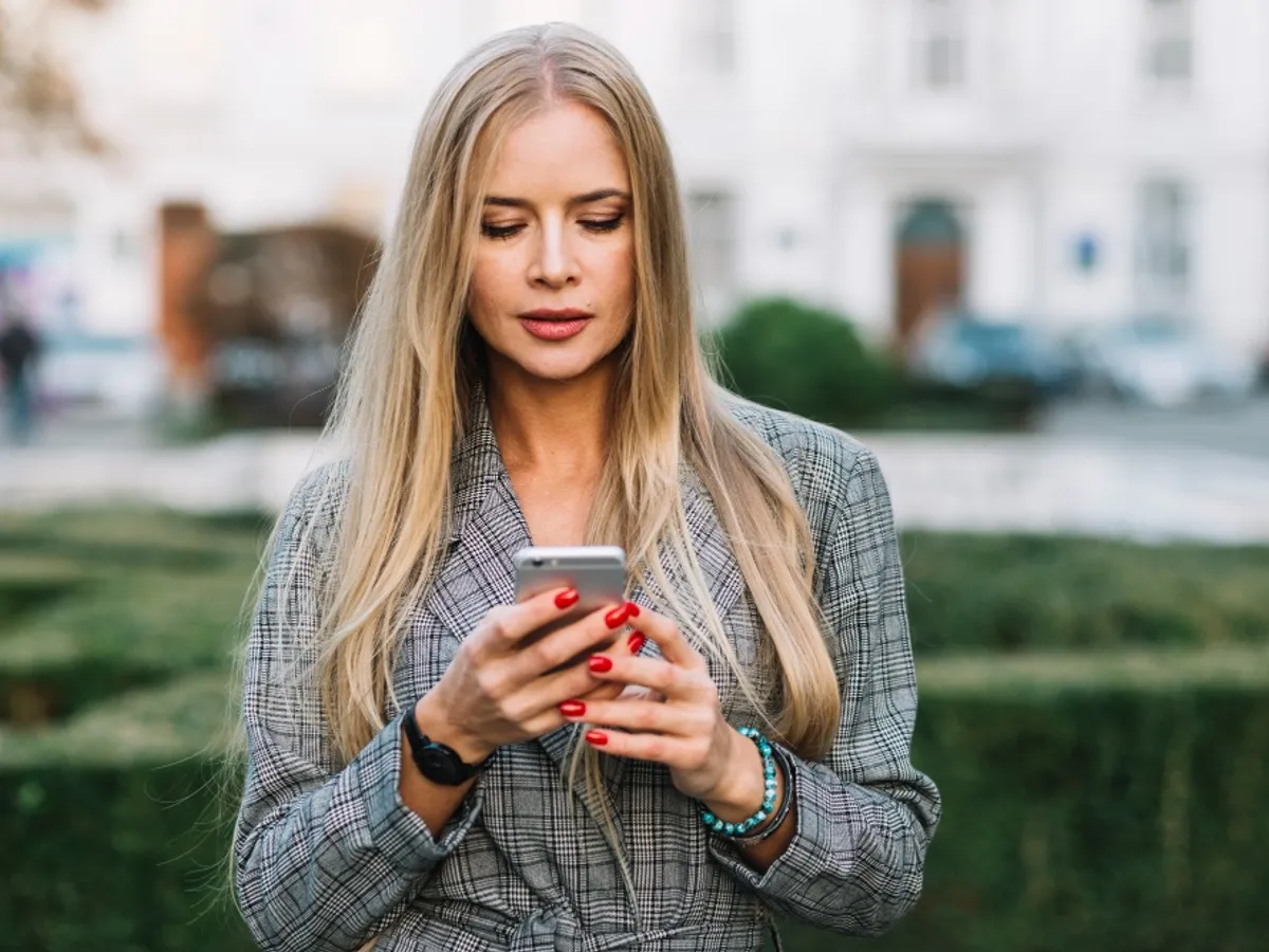 O femeie citește mesaje pe telefon - Foto: Freepik (rol ilustrativ)