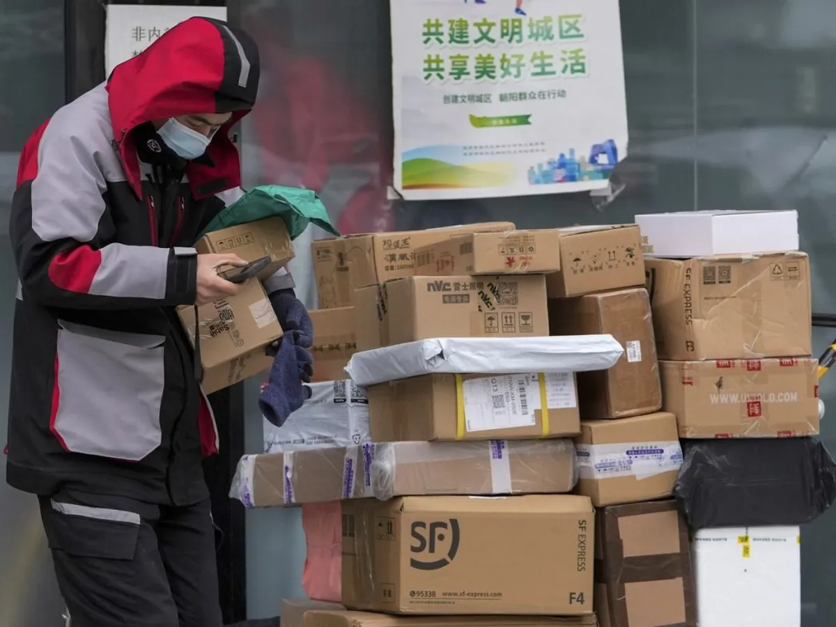 Se întâmpla încă din 2021. Un curier de la o companie privată ridică mai multe colete, pentru export, în Beijing, China - Foto: Profimedia Images