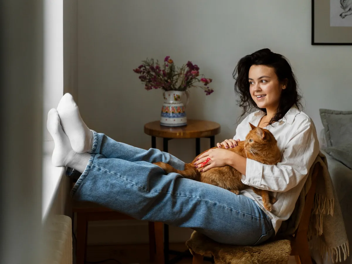 Femeie care ține o pisică în brațe - Foto: Freepik (Imagine cu rol ilustrativ)