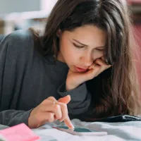 Femeie frumoasă calculându-şi impozitul pe venit - Foto: Magnific.com/teksomolika