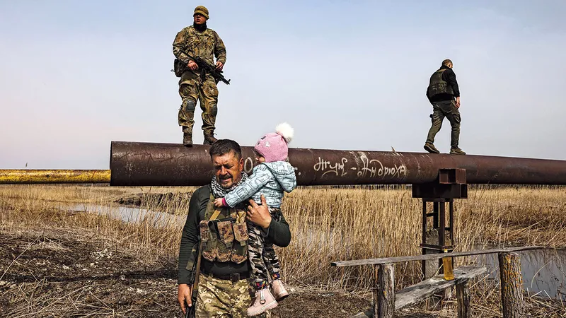 Un militar ucrainean ajută un copil strămutat în afara Kievului