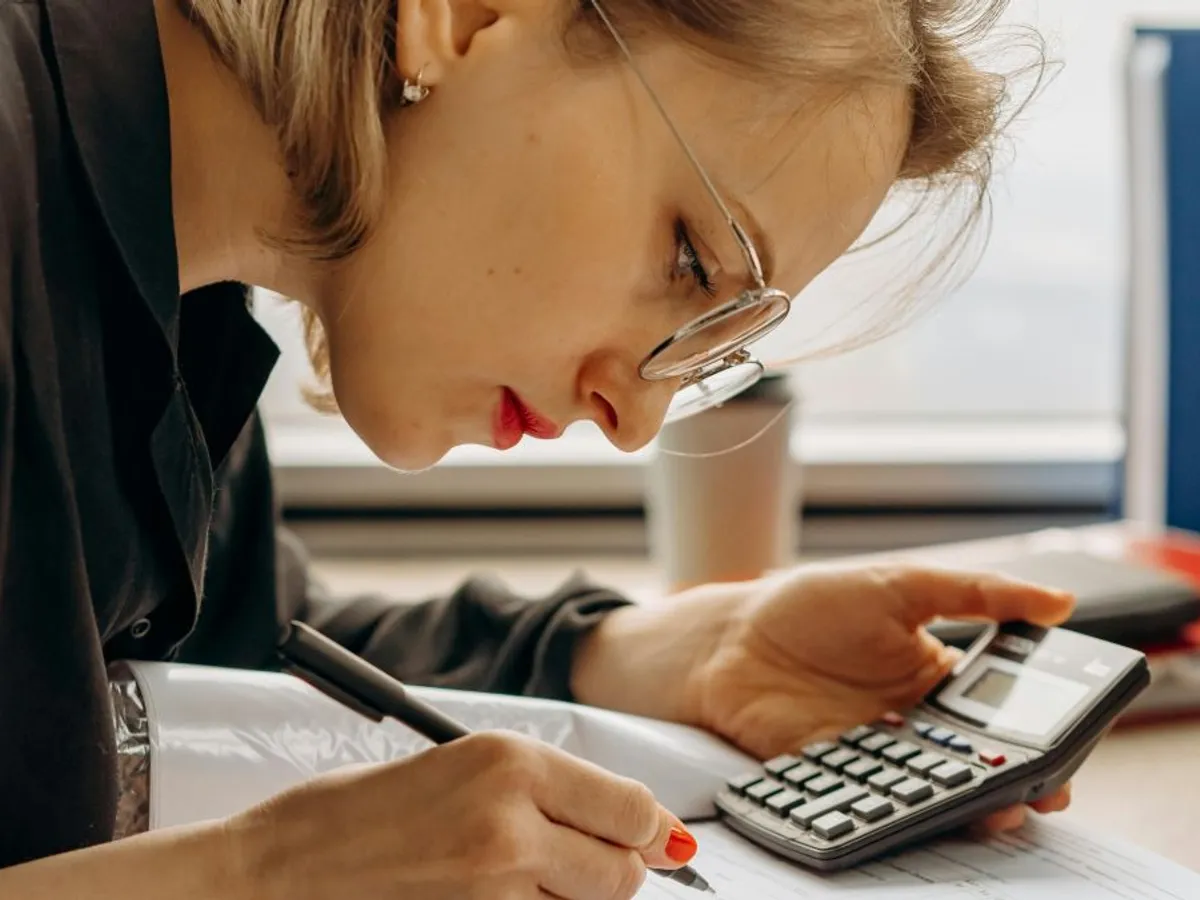 Femeie făcând calcule complicate - Foto: Pexels/Mikhail Nilov