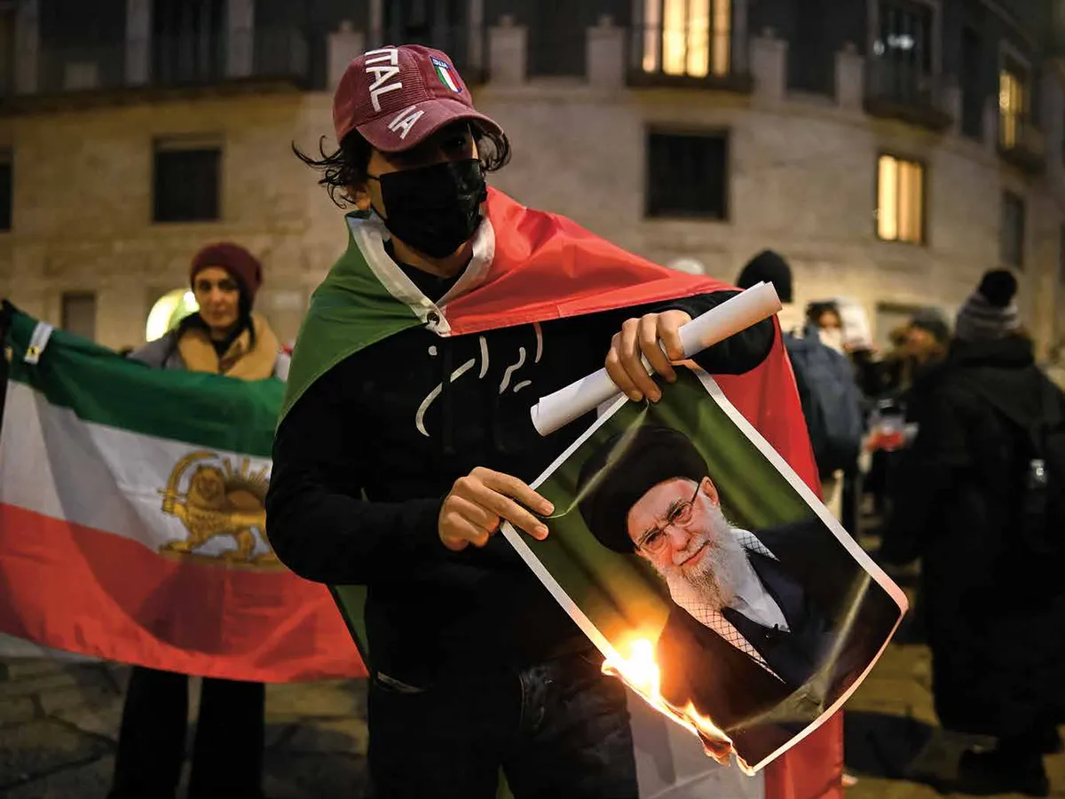 Un Iranian dă foc portretului Ayatolahului Ali Khamenei, liderul suprem al Iranului, în timpul unui protest în Milano - Foto: Profimedia Images