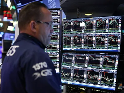Trader uitându-se consternat, pe 10 aprilie, cum toate graficele de evoluţie indică o bursă New York Stock Exchange pe roşu - Foto: Profimedia Images