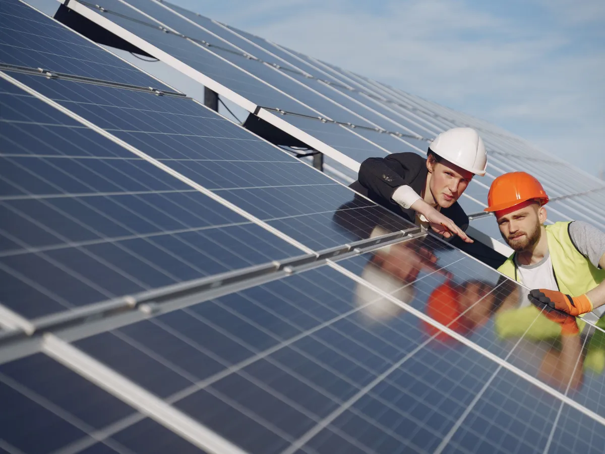 Doi bărbați așezați pe panouri fotovoltaice - Foto: Freepik (rol ilustrativ)