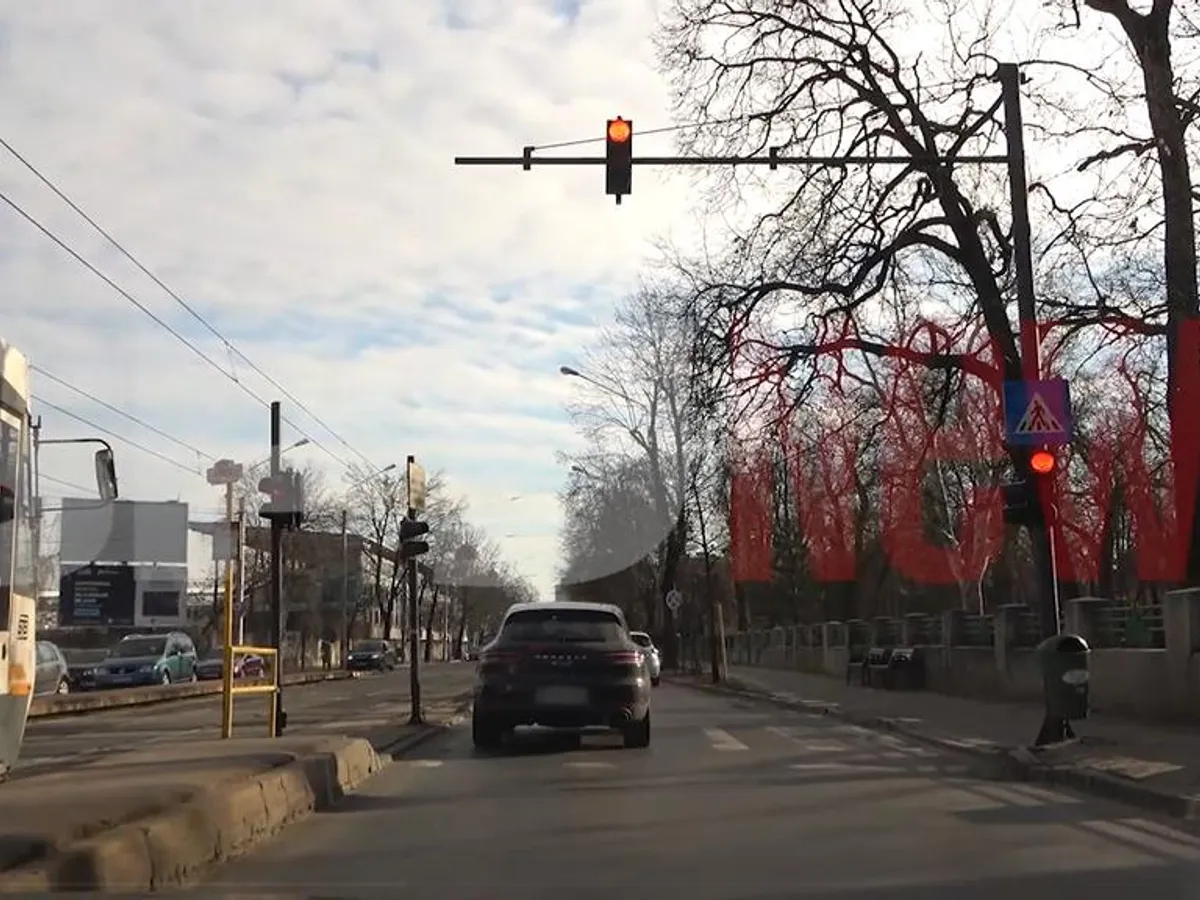 Ginerele lui Adriean Videanu trece cu Porsche-ul pe roșu și depășește pe linia de tramvai. / Foto: captură video
