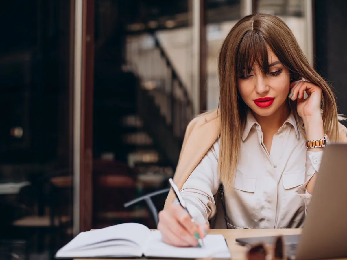 Femeie de afaceri făcând calcule de business în cafenea - Freepik/senivpetro