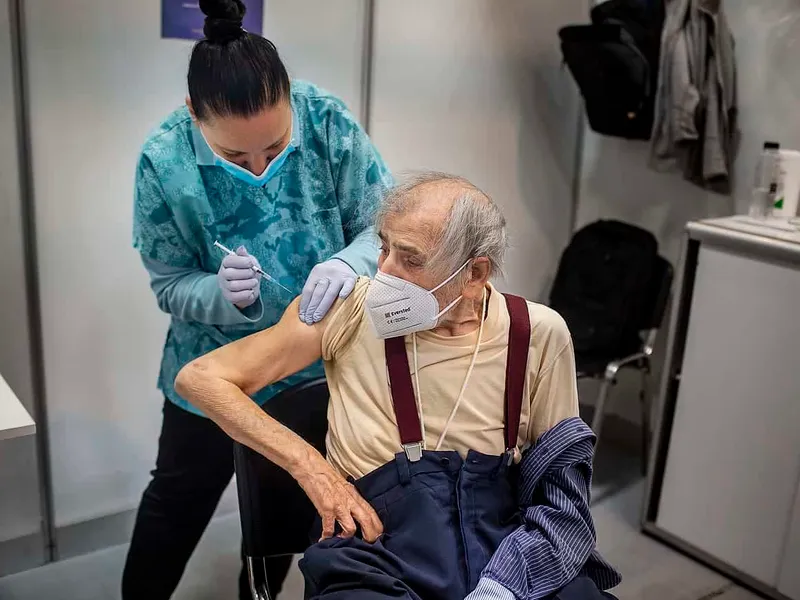 Petre Negut (91) receiving the Pfizer-BioNTech COVID-19 vaccine at Romexpo in Bucharest, Romania Photo: Mugur VARZARIU/Getty Images/Newsweek