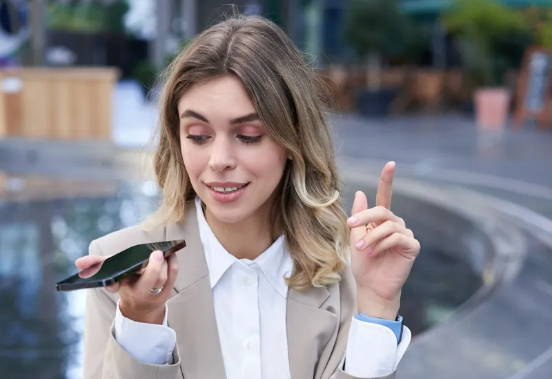 Femeie z&acirc;mbitoare făc&acirc;nd o operaţiune de banking prin telefonul mobil - Foto: Freepik/benzoix