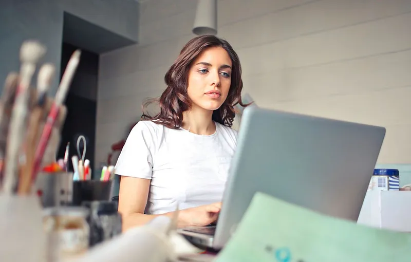 Femeie frumoasă lucr&acirc;nd pe laptop - Foto: Pexels/Andrea Piacquadio