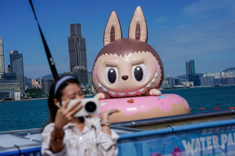 O femeie care își face un selfie cu o sculptură gonflabilă plutitoare Labubu, în Hong Kong - Foto: Profimedia Images