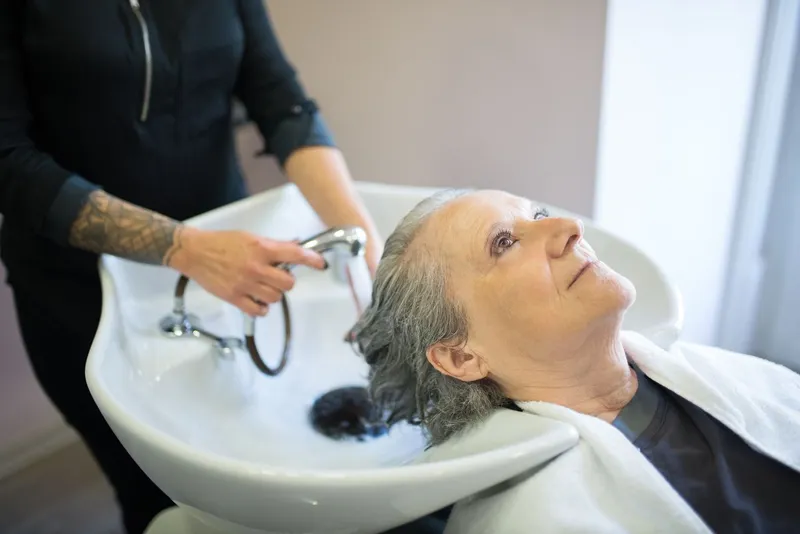 Femeia &icirc;n v&acirc;rstă &icirc;și spală părul de către un stilist &icirc;ntr-un salon  - Foto: Pexels (Imagine cu rol ilustrativ)