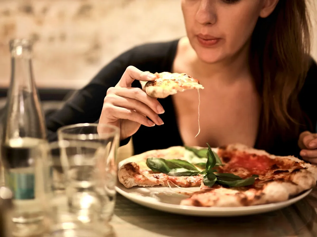 Femeie mancand pizza