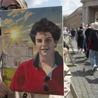 Fotografie cu Carlo Acutis, a cărui canonizare a fost amânată, în timp ce tinerii se adună pentru o liturghie pentru regretatul Papă Francisc, În Piaţa Sf. Petru, la Vatican - Foto: Profimedia Images