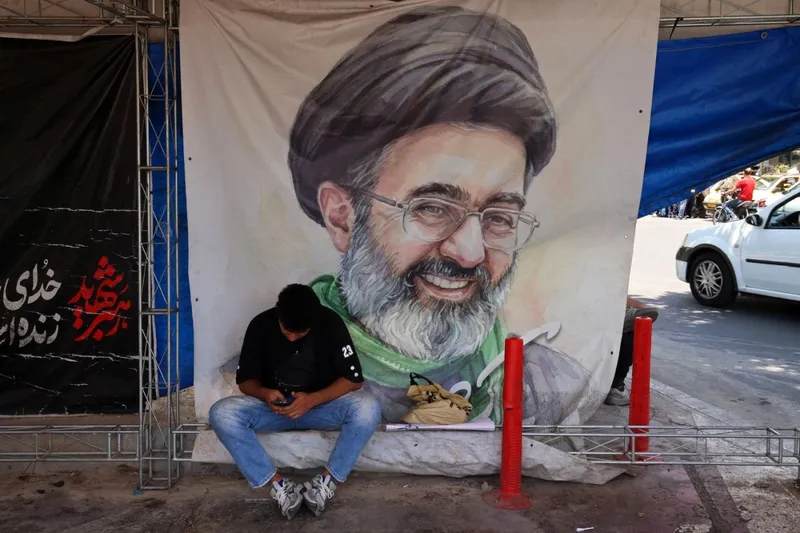Un bărbat stă &icirc;n fața unui poster cu portretul lui Mojtaba Khamenei, &icirc;n Piața Vanak, din Teheran - Foto: Profimedia Images