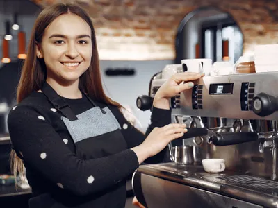 Tănără prepară un espresso - Foto: Magnific.com (cu rol ilustrativ)