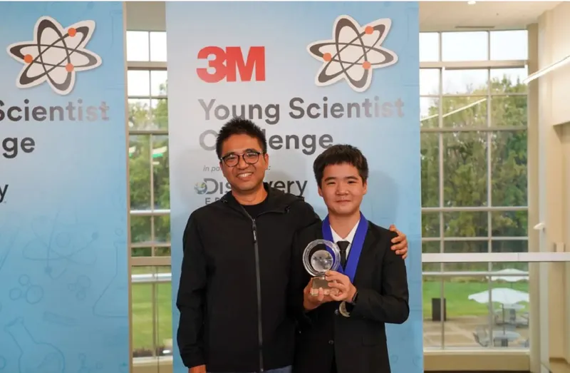 Kevin Tang ține trofeul premiului &icirc;nt&acirc;i, &icirc;n timp ce stă alături de tatăl său. - Foto: Business Insider