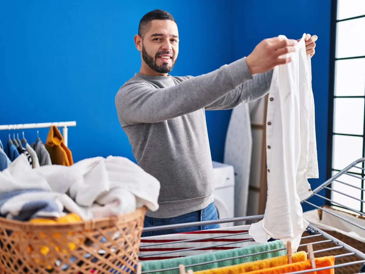 Bărbat care întinde rufele - Foto:Freepik (Imagine cu rol ilustrativ)