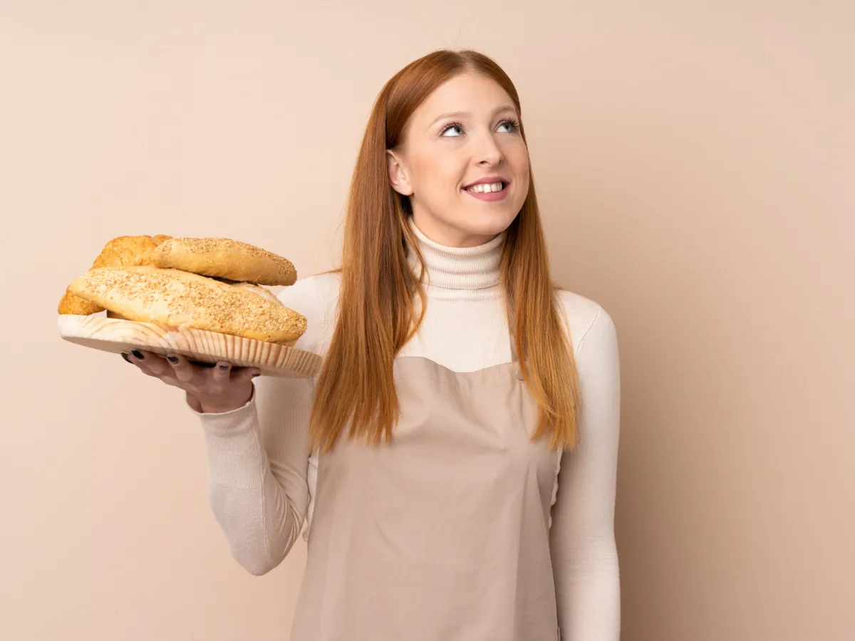 Femeie care ține în mână pâini - Foto: Freepik (Imagine cu rol ilustrativ)