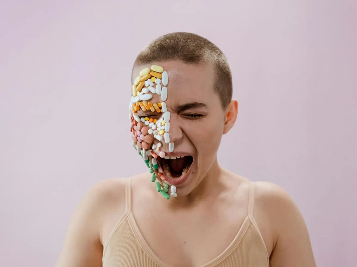 Femeie în maiou alb cu faţa decorată cu pastile multicolore - Foto: Pexels/cottonbro studio