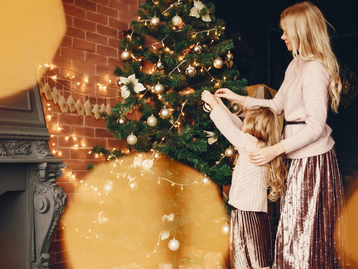 Familie care pune în brad globuri - Foto: Freepik (Imagine cu rol ilustrativ)