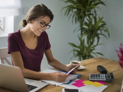 Tânără femeie calculându-şi profitul la investiţia în titluri de stat - Foto: Magnific.com/gpointstudio