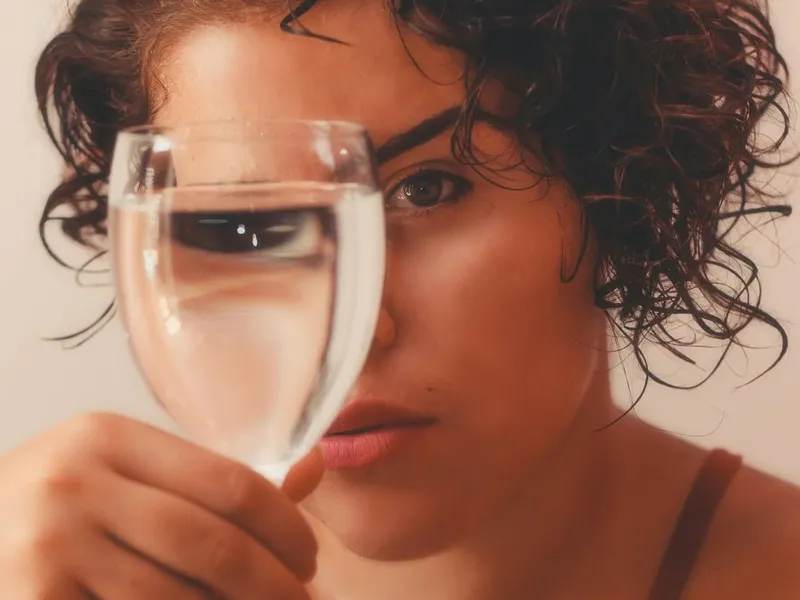 Femeie ţinând în mână un pahar cu apă - Foto: Pexels/Alexandro David