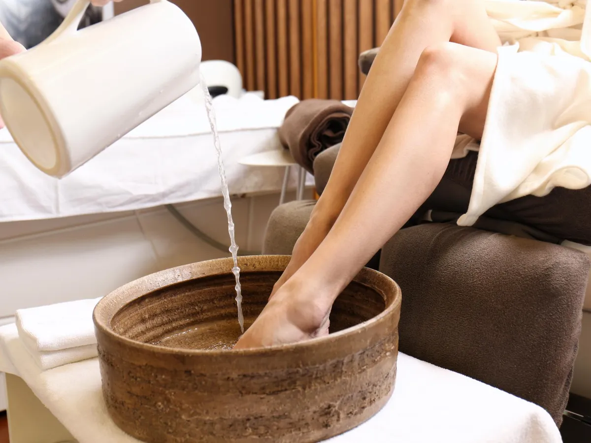 Persoană care stă cu picioarele într-un vas cu apă caldă - Foto: Freepik (Imagine cu rol ilustrativ)