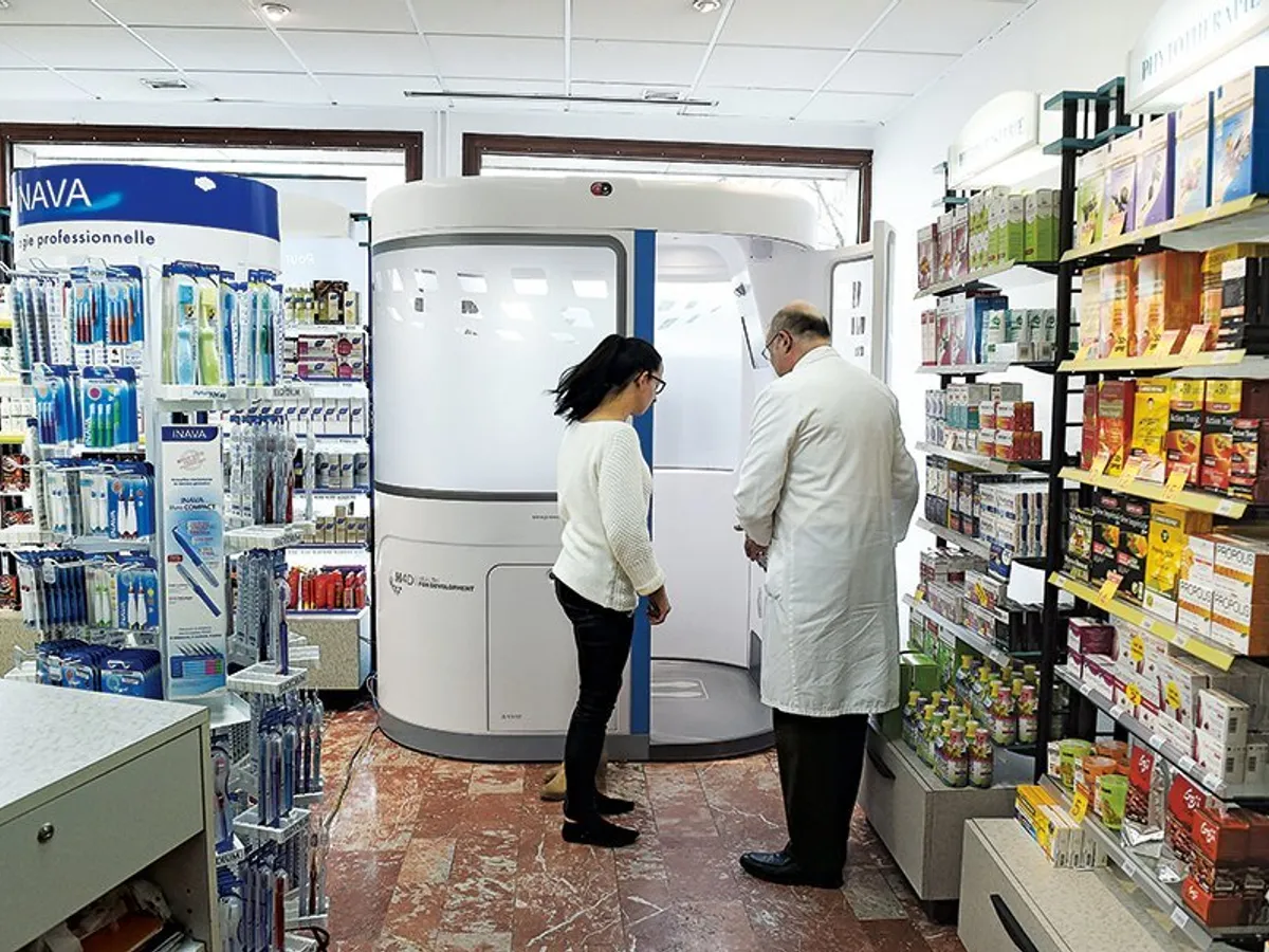 Un pacient din Roanne, Franța, folosește o cabină de telemedicină la o farmacie locală