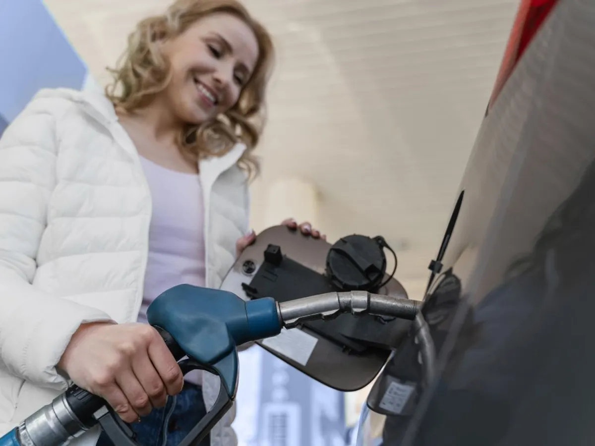 Femeie făcând plinul, la o pompă de carburant - Foto: Magnific.com/magnific